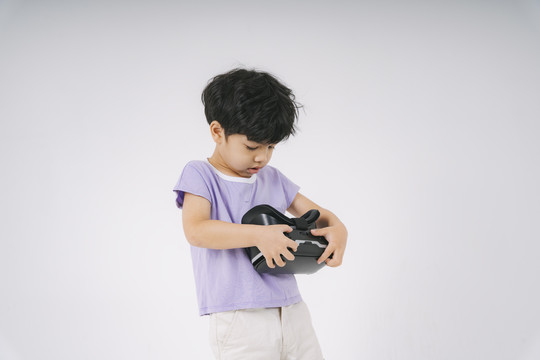 穿着紫色t恤的小男孩戴着VR护目镜，享受新的体验。