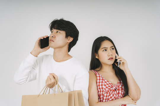 这对夫妇一起去购物，但他们迷路了，所以他们用智能手机打电话给对方。