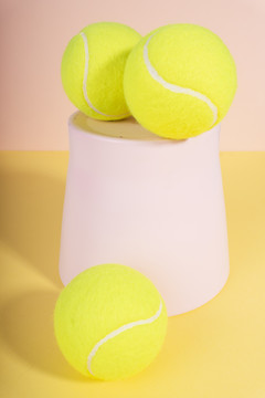 粉彩背景上粉红色篮子上的三个网球。
