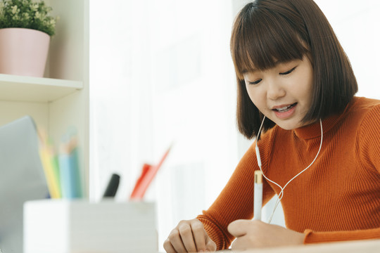 美丽的年轻亚泰黑人短发女子学习从家里学习在线笔记本电脑和戴耳机。