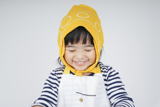 快乐美丽的泰国亚裔小孩的肖像，戴着黄色绷带，在白色的脸上带着幸福的微笑。