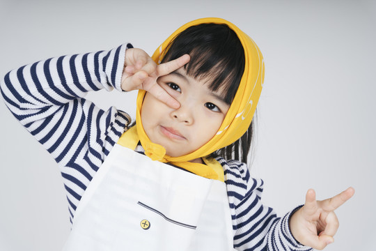 戴着黄色绷带的泰国亚裔漂亮孩子在白色背景上露出两个手指。