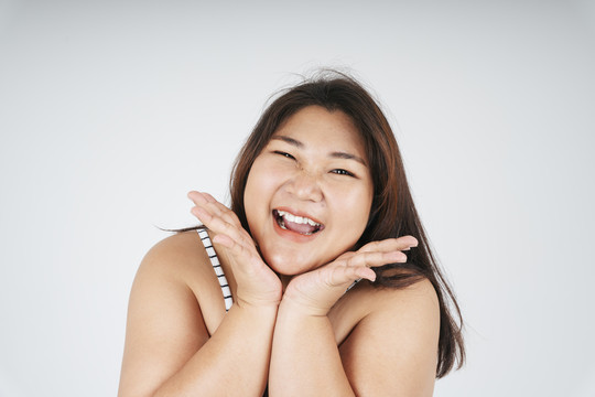 白色背景上快乐健康亚洲胖女人的特写镜头。