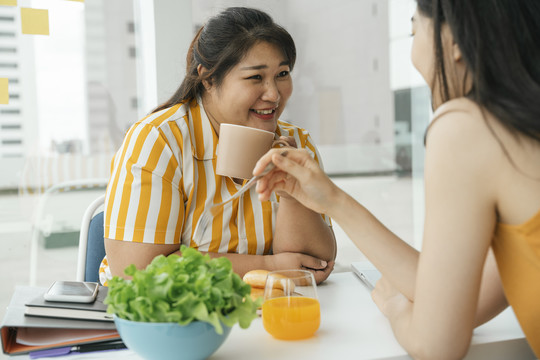 亚洲胖女人喜欢和朋友一起吃健康的午餐。