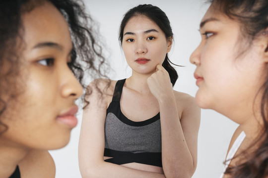 站在胖女人和非洲女人中间的亚洲女商人的肖像。