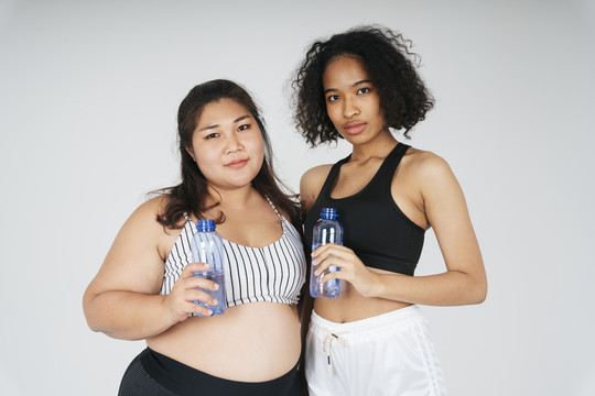 混血非洲和泰国和胖乎乎的妇女与水瓶白色背景。