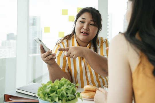 亚洲胖女人用智能手机订购食物。