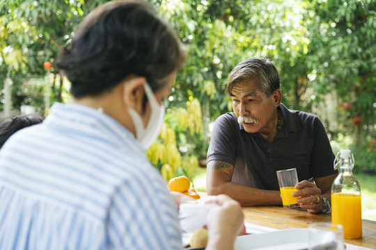 外孙父母一起在野餐的地方喝橙汁。