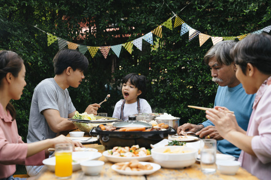 亚洲人喜欢在户外的院子里吃烧烤来庆祝聚会。