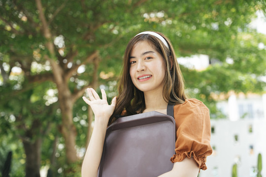 美丽的亚洲女服务员在户外穿着围裙和白色头巾的肖像。