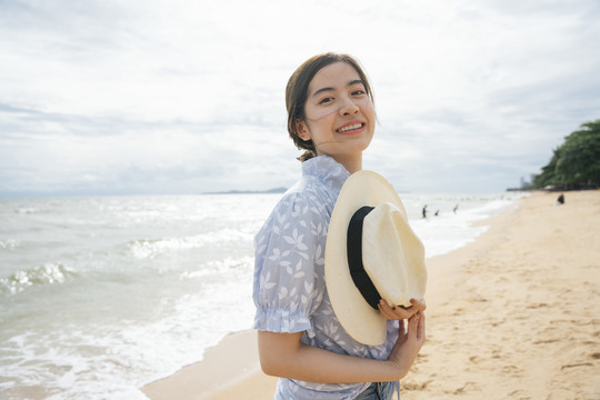 海滩上美丽的亚洲女游客的时尚写真。