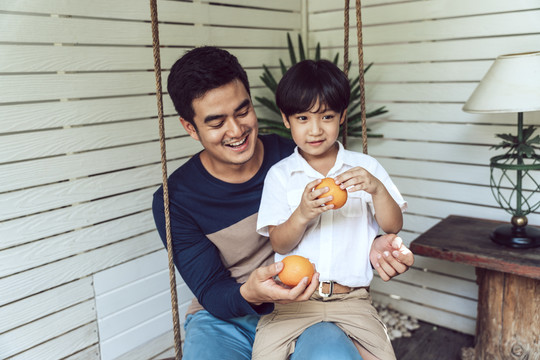 亚裔父子早餐或午餐都喜欢吃橘子。