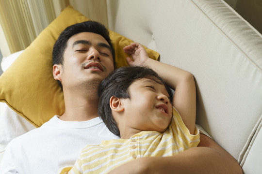 睡在床上的亚泰父子相互拥抱。