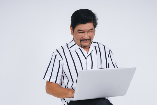 在白色背景上，穿着白领衬衫的老人用笔记本电脑拍摄的肖像。