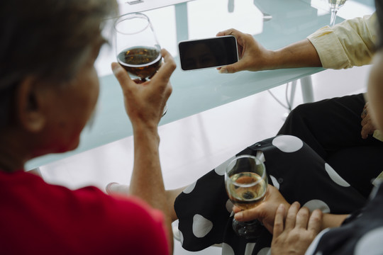 老年人喜欢看桌上的智能手机屏幕喝酒。