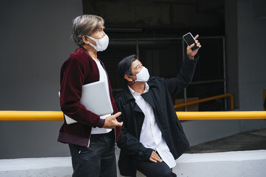 两个戴着面具的高级工程师指着城市里的大楼。