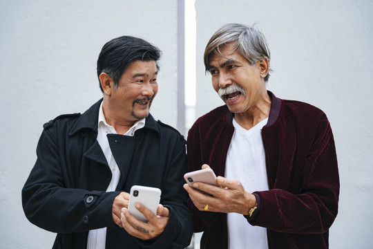 两位上了年纪的老人一起使用智能手机的照片。