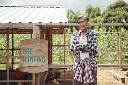 当地养鸡场的亚洲老年农民。