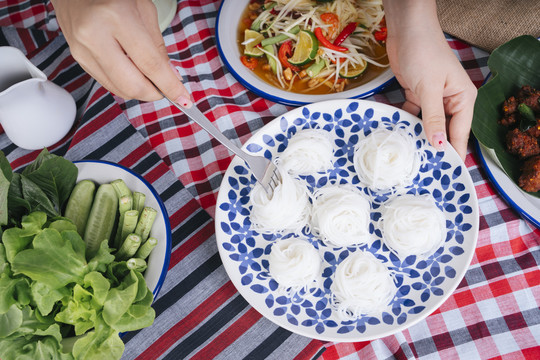 顶视图-人们在吃米粉的同时也在吃一种食物。