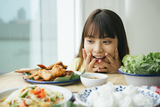 一幅年轻的亚洲妇女看着桌子上的食物，表情惊异的画像。