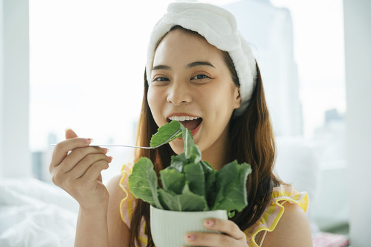 年轻的亚洲黑发白发女子喜欢吃有机蔬菜沙拉。