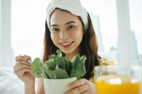 年轻的亚洲黑发白发女子喜欢吃有机蔬菜沙拉。