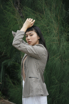 自然背景下穿着正式衬衫的亚洲女商人的时尚肖像。