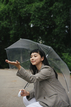 穿着正式衬衫、手持透明伞的亚洲女商人的时尚肖像。