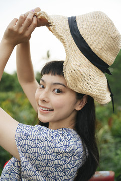 大自然中戴草帽的快乐旅行家亚洲女人的肖像。