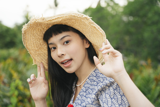大自然中戴草帽的快乐旅行家亚洲女人的肖像。