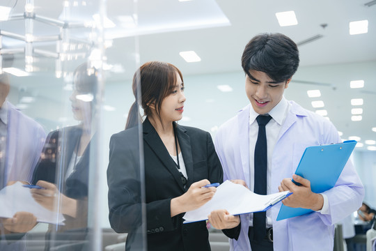 年轻的亚洲医生和美丽的秘书一起在医院或诊所工作。