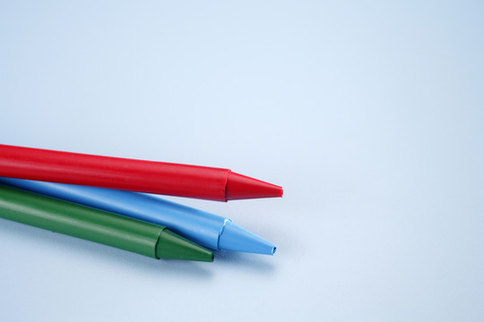 三支蜡笔分别放在蓝色背景上。