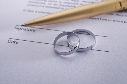 两枚戒指和一支笔的结婚证。