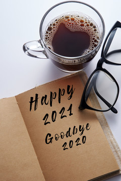 便笺簿上写着2021年快乐，2020年再见，喝杯咖啡