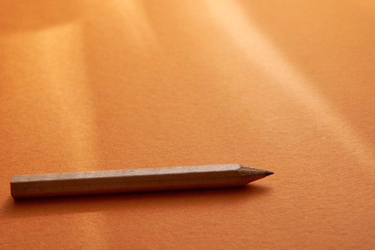 橙色背景的短铅笔