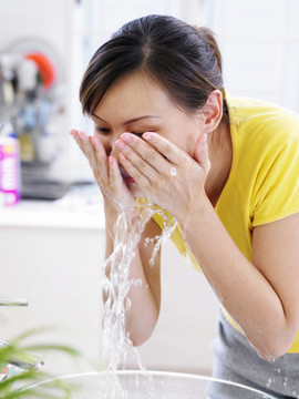 年轻的女士在洗脸