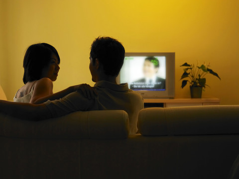 一对年轻夫妇在客厅看电视