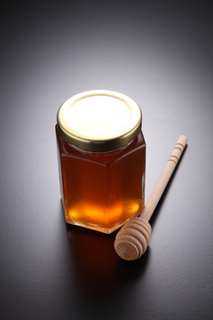 蜂蜜放在装有木勺的玻璃容器里