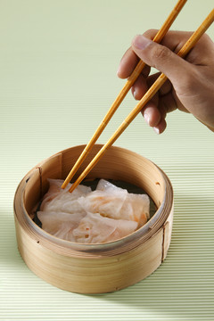 手拿筷子伸手去拿零食。