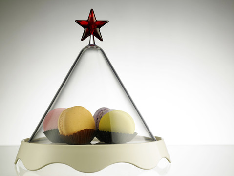 五颜六色的macaron装在三角形玻璃容器里，上面有星星