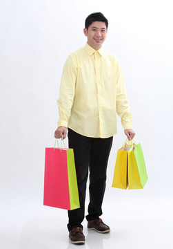 中国男人手里拿着几个五颜六色的购物袋