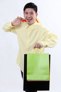 中国男人手里拿着几个五颜六色的购物袋