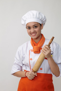 一个穿着厨师制服拿着擀面杖的印度女人的肖像