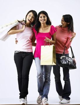 3个女孩在朴素的背景下一起购物