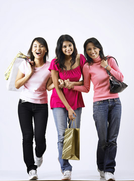 3个女孩在朴素的背景下一起购物