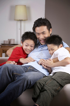 父亲和两个儿子在客厅里拥抱