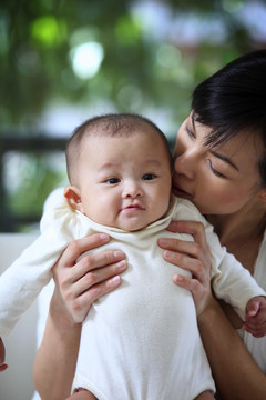 妈妈从背后亲吻她的孩子