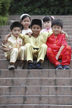 穿着传统服装坐在公园里的多种族儿童
