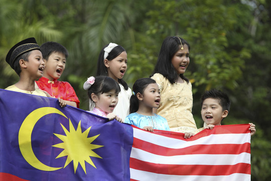 手持马来西亚国旗的多种族儿童侧视图