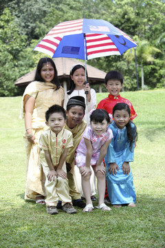 多种族儿童在一把伞下合影